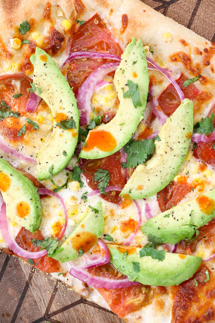 Vegetarian Roasted Corn and Avocado pizza with fresh Heirloom Tomatoes, red onion, and Cholula with an Avocado Cream Sauce - The new Cinco De Mayo Party Food Recipe
