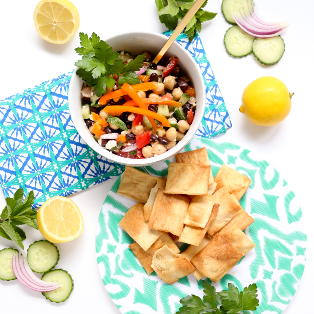 Greek Garbanzo Bean Salsa Dip filled with fresh mint and parsley, black beans, tomatoes, cucumbers, feta cheese, and a lemon vinaigrette. The perfect salad for a pot luck, BBQ, or picnic! Make ahead salad.