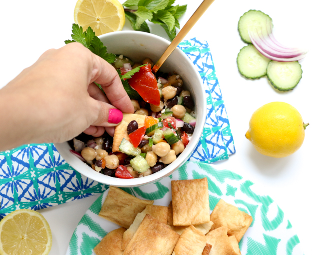 Greek Garbanzo Bean Salsa Dip filled with fresh mint and parsley, black beans, tomatoes, cucumbers, feta cheese, and a lemon vinaigrette. The perfect salad for a pot luck, BBQ, or picnic! Make ahead salad.